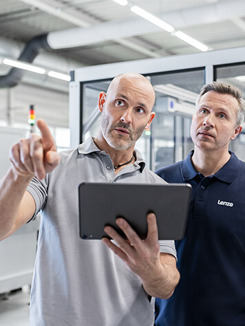 Two men with a tablet looking at something. ​  Presentation of digital services. 