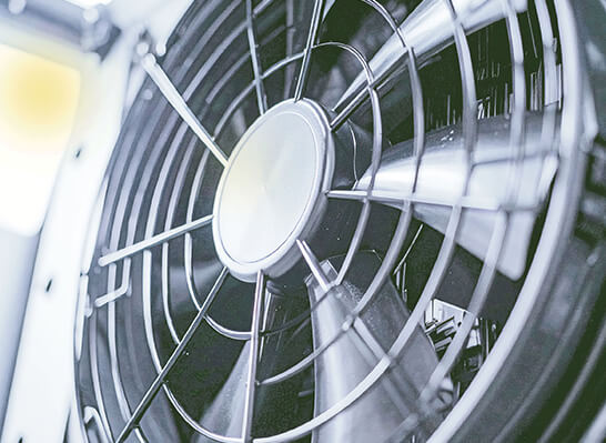 Nahaufnahme eines Ventilators mit Schutzgitter, eingesetzt zur Luftzirkulation und Wärmeabfuhr in Kälte- und Lüftungsanlagen